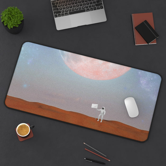 Astronaut's Arrival on Planet X Mouse Pad Desk Mat: blue-gray, pink astronaut on a moonlike landscape beneath a large planet