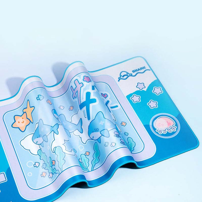 Cute Shark Gaming Desk Mat with Ocean Vibes: cyan blue, white cartoon sharks and sea-themed characters, kawaii cartoon style