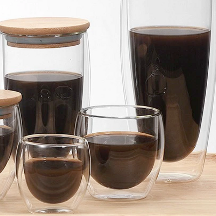 Double Wall Glass Cup that is Resistant to Heat: clear, dark brown double-walled drinking glass with dark beverage, minimal s