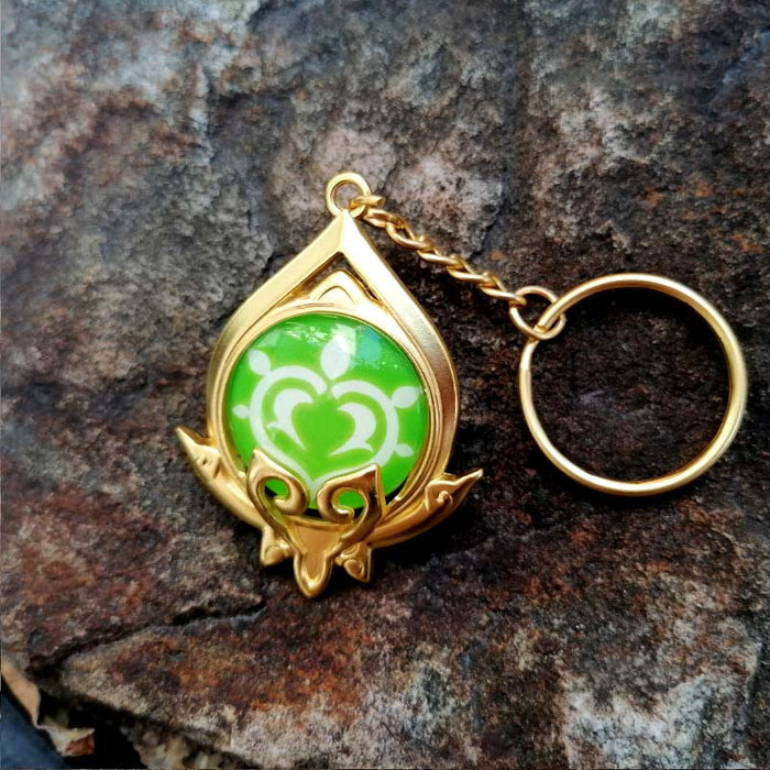 Genshin Impact Sumeru Vision Keychain: gold, turquoise stylized octopus-like emblem, fantasy emblem style