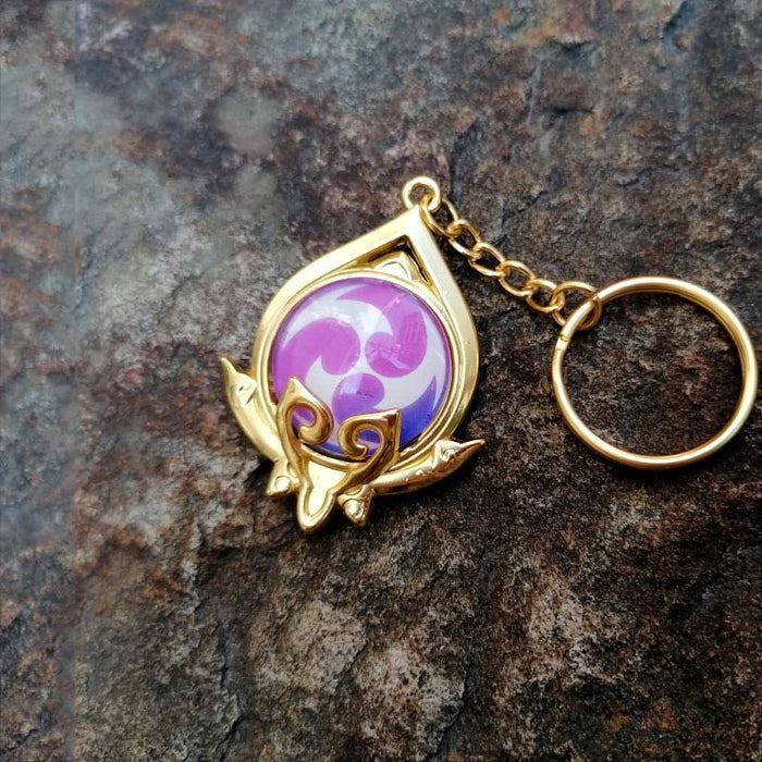Genshin Impact Sumeru Vision Keychain: gold, turquoise stylized octopus-like emblem, fantasy emblem style