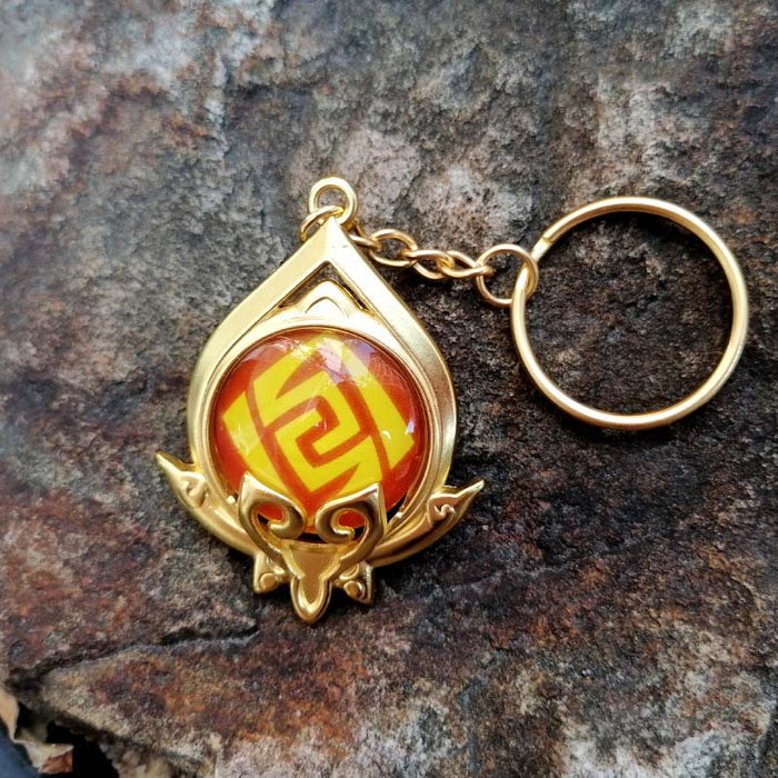 Genshin Impact Sumeru Vision Keychain: gold, turquoise stylized octopus-like emblem, fantasy emblem style
