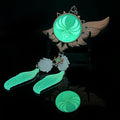 Genshin Impact Venti Vision Keychain: glowing turquoise green, brown fantasy winged emblem with feather charms, fantasy carto