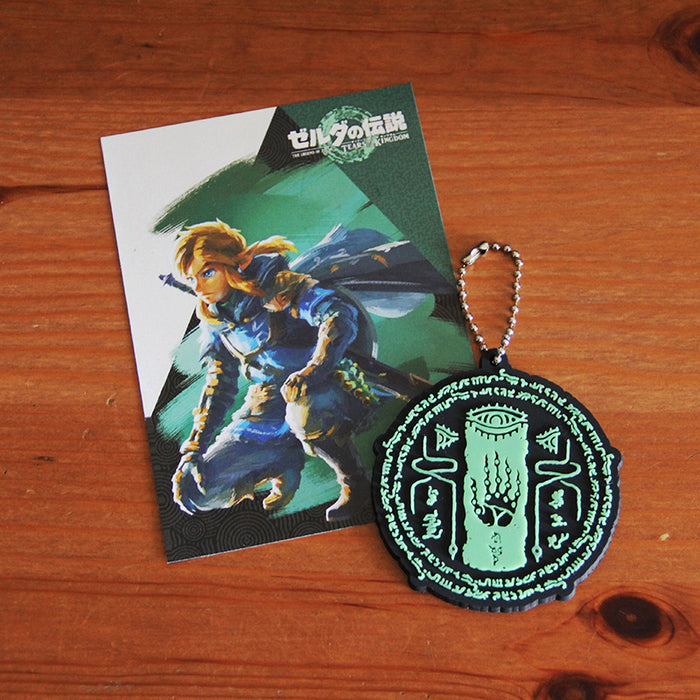 Glow in the Dark Zelda Keychains: black, mint green stylized mystical eye and hand symbol, graphic, occult-inspired, cartoon