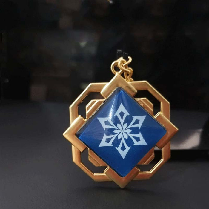 Liyue Vision Key Chain: Genshin Impact: gold, teal stylized white floral/crest emblem, fantasy-inspired geometric style