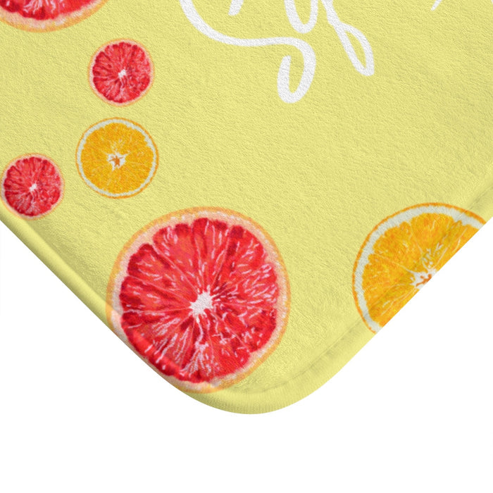 Squeeze the Day Citrus Bath Mat: light yellow, red-pink citrus fruit theme, bright playful graphic style