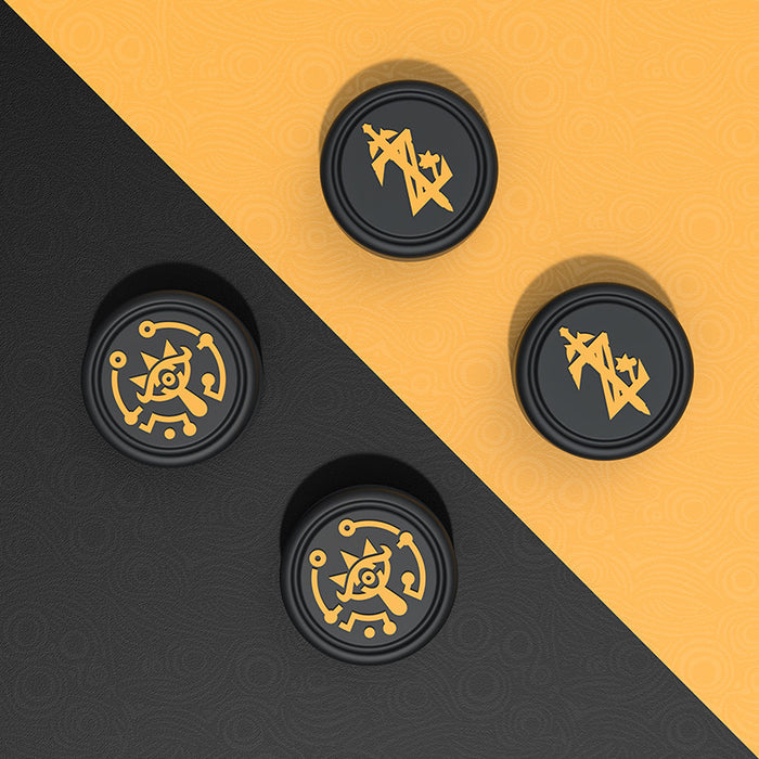 Zelda Joystick Caps with Sheikah Slate: black, gold/yellow stylized symbols/emblems, minimal graphic, game-token-like style