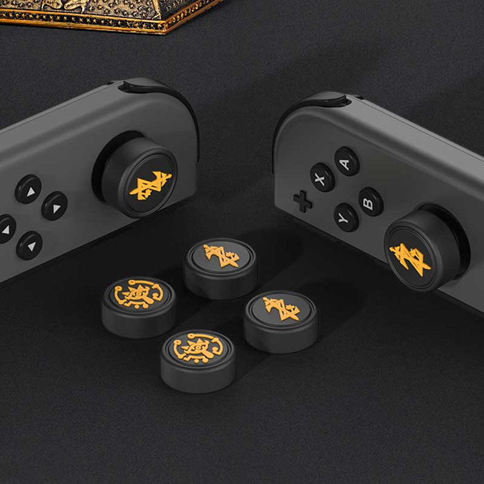 Zelda Joystick Caps with Sheikah Slate: black, gold/yellow stylized symbols/emblems, minimal graphic, game-token-like style