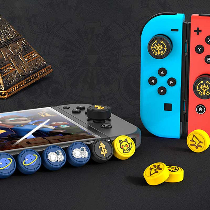 Zelda Joystick Caps with Sheikah Slate: black, gold/yellow stylized symbols/emblems, minimal graphic, game-token-like style